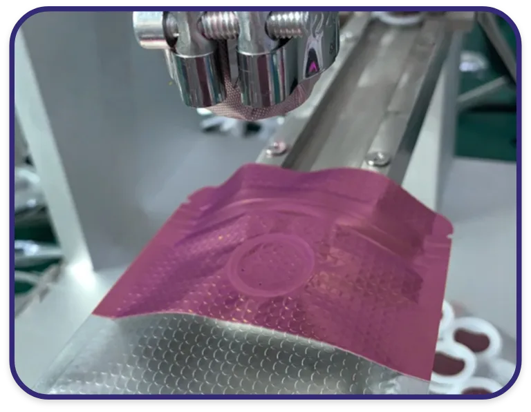 Coffee Pouch with Valve Under Automated Sealing Head Close-up of a degassing valve being installed on a custom printed coffee pouch using precision heat sealing equipment.